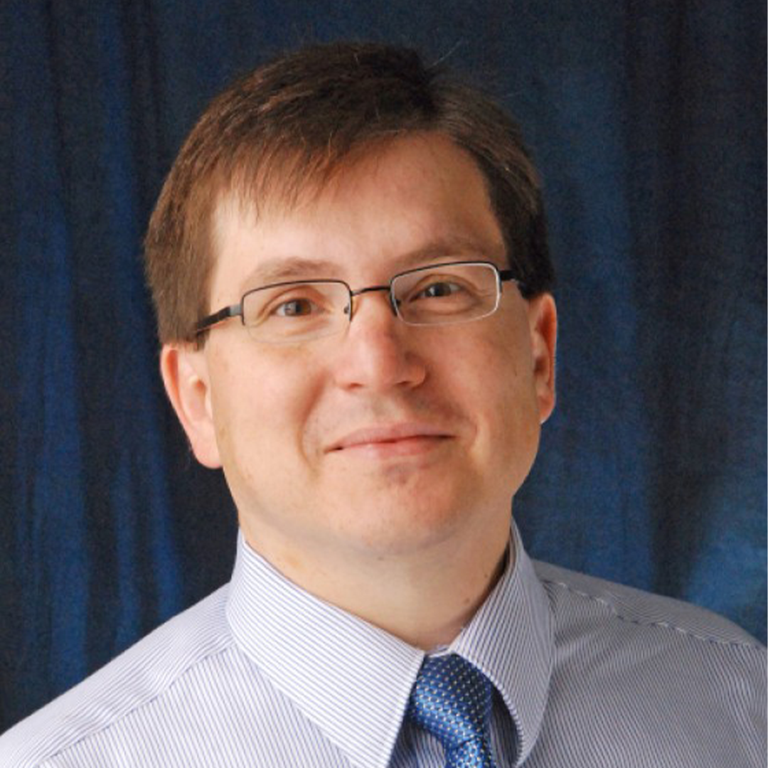 headshot of a white man with light brown hair and glasses
