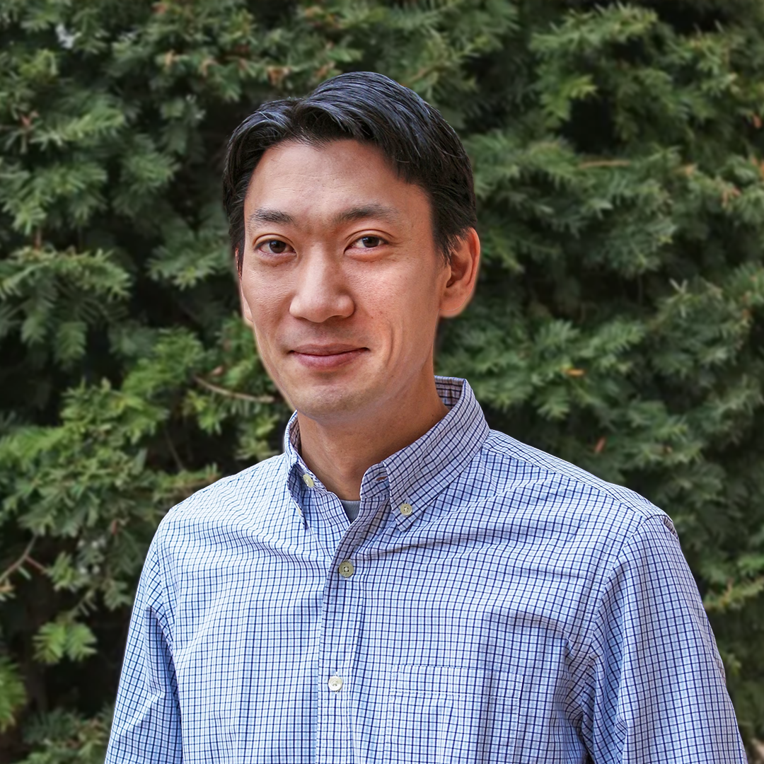 headshot of an asian man with short black hair and a blue button up shirt